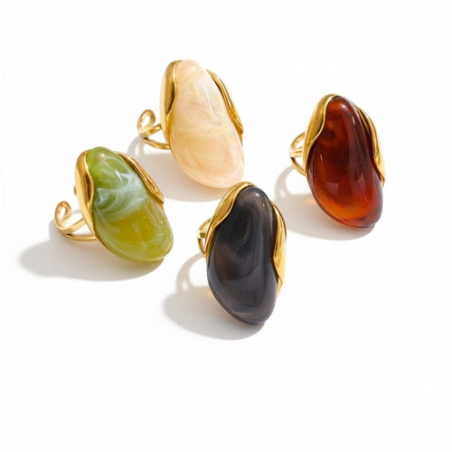 Lyza Jewels, LLC artistic cocktail ring with a marbled cream resin stone in a gold-tone frame. Water-resistant stainless steel.