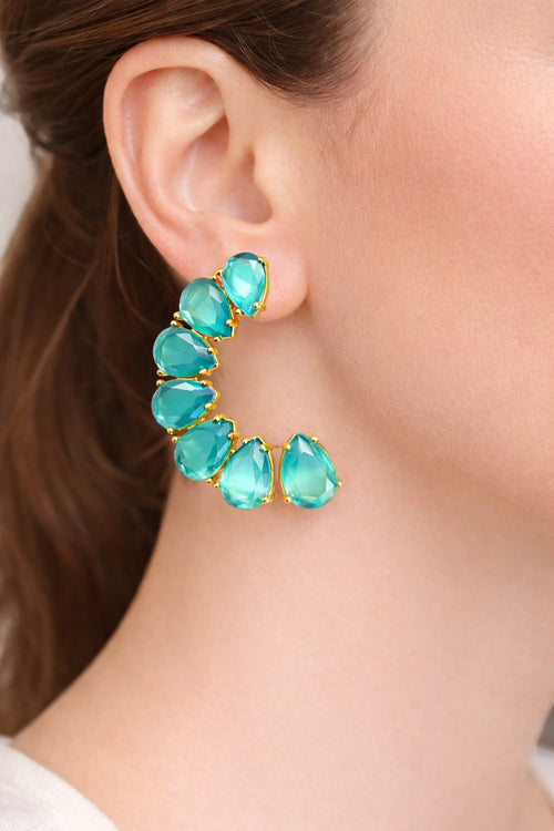 Lyza Jewels, LLC 18K gold plated brass earrings with teardrop turquoise stones in a crescent shape.