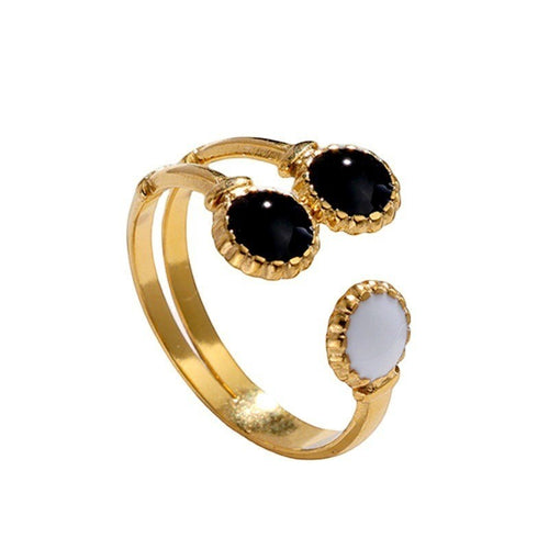 Lyza Jewels, LLC adjustable 18k gold plated stainless steel ring with two black oval stones and one white oval stone.
