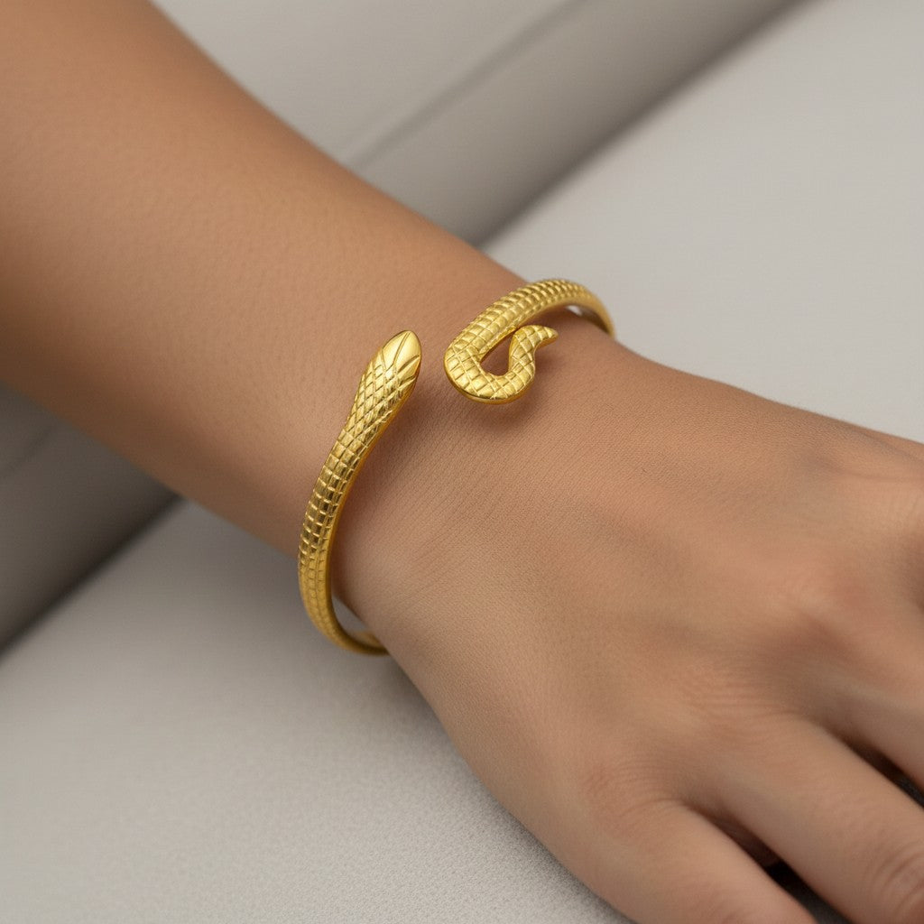 Lyza Jewels, LLC 18k gold stainless steel snake bangle bracelet with textured scale detail on a woman's wrist.