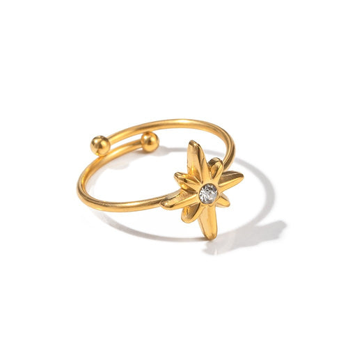 Lyza Jewels, LLC gold stainless steel adjustable ring with an eight-pointed star design and a central cubic zirconia stone.
