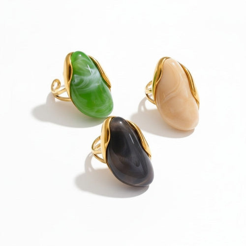 Lyza Jewels, LLC artistic cocktail rings in cream, green, and grey marbled resin with gold-tone frames.