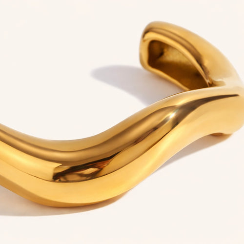 Lyza Jewels, LLC gold-tone wavy sculptural cuff bracelet with a high-polish finish and modern minimalist design.